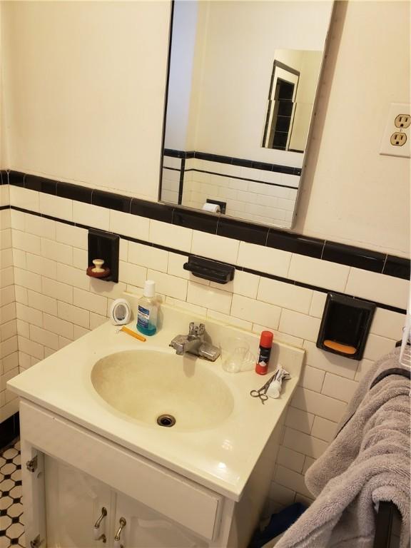 106 Langdon St, Providence, RI 02904 - bathroom featuring tile walls, vanity, and wainscoting