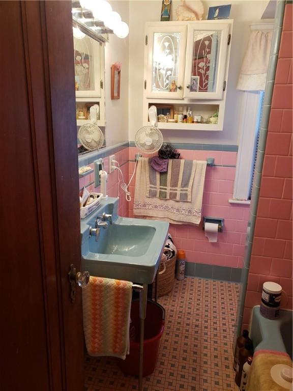 106 Langdon St, Providence, RI 02904 - bathroom with tile walls, wainscoting, and a tub