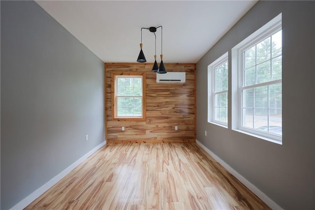 154 Foster Center Rd, Foster, RI 02825 - unfurnished dining area featuring wooden walls, plenty of natural light, wood finished floors, a wall mounted AC, and an accent wall