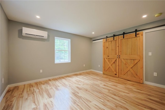 154 Foster Center Rd, Foster, RI 02825 - spare room featuring a wall unit AC, a barn door, light wood-style floors, recessed lighting, and a smoke detector