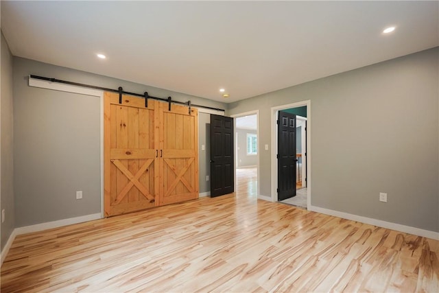 154 Foster Center Rd, Foster, RI 02825 - unfurnished bedroom with light wood-style floors, a barn door, and recessed lighting