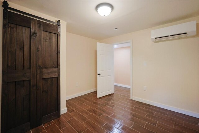 154 Foster Center Rd, Foster, RI 02825 - unfurnished bedroom featuring an AC wall unit, dark wood-type flooring, and a barn door