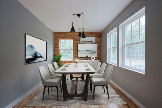 154 Foster Center Rd, Foster, RI 02825 - dining space featuring an accent wall, wood walls, wood finished floors, and a wall mounted AC