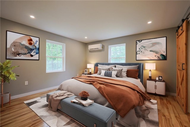 154 Foster Center Rd, Foster, RI 02825 - bedroom with a barn door, a wall mounted air conditioner, light wood-style flooring, and recessed lighting