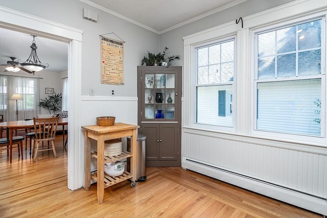25 Sheffield Ave, North Providence, RI 02911 - dining space with a baseboard heating unit, wainscoting, light wood-type flooring, ceiling fan, and crown molding