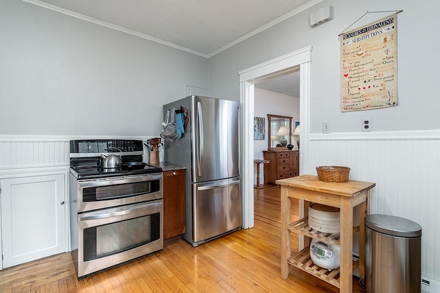 25 Sheffield Ave, North Providence, RI 02911 - kitchen featuring appliances with stainless steel finishes, a wainscoted wall, light wood-style floors, ornamental molding, and a baseboard radiator