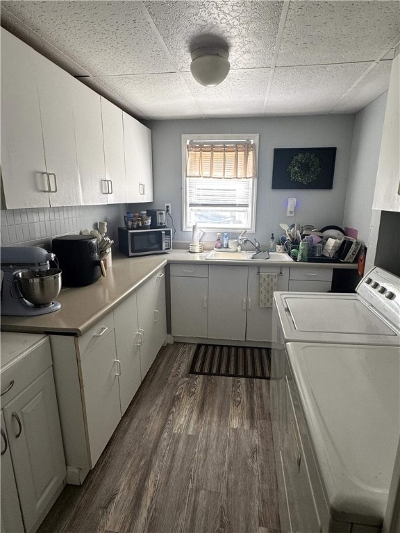 494 Grove St, Woonsocket, RI 02895 - kitchen with stainless steel microwave, washing machine and clothes dryer, dark wood finished floors, a paneled ceiling, and light countertops