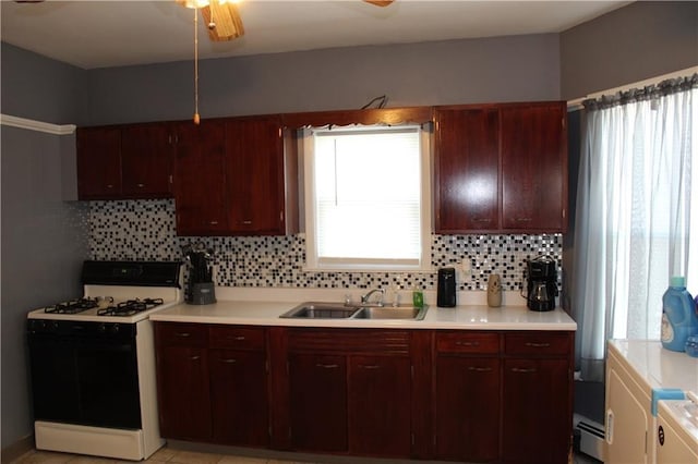 494 Grove St, Woonsocket, RI 02895 - kitchen featuring range with gas stovetop, washing machine and dryer, light countertops, and backsplash