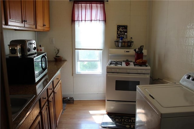 494 Grove St, Woonsocket, RI 02895 - kitchen with washer / clothes dryer, white gas range, and light wood finished floors