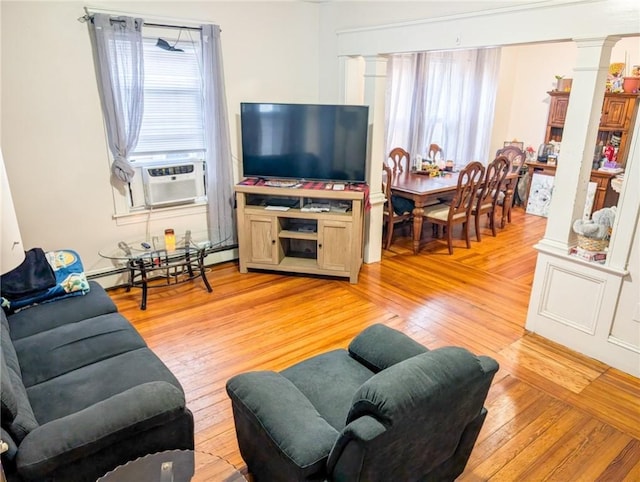 10 Stamford Ave, Providence, RI 02907 - living room with decorative columns, a baseboard heating unit, light wood-style flooring, and plenty of natural light