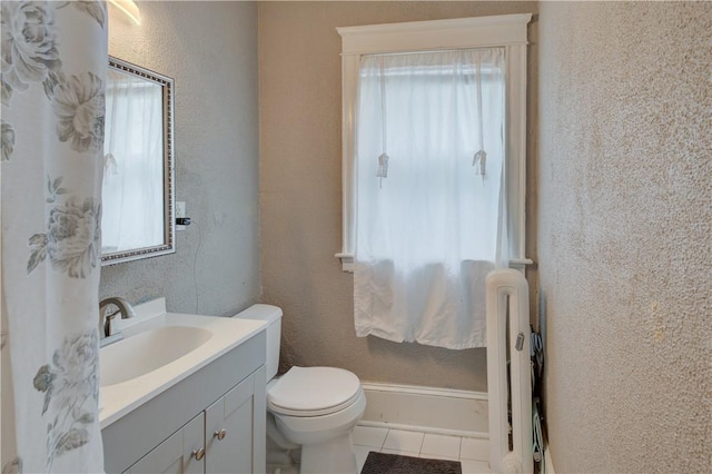 58 Cliffdale Ave, Cranston, RI 02905 - bathroom with healthy amount of natural light, vanity, radiator, tile patterned floors, and a textured wall