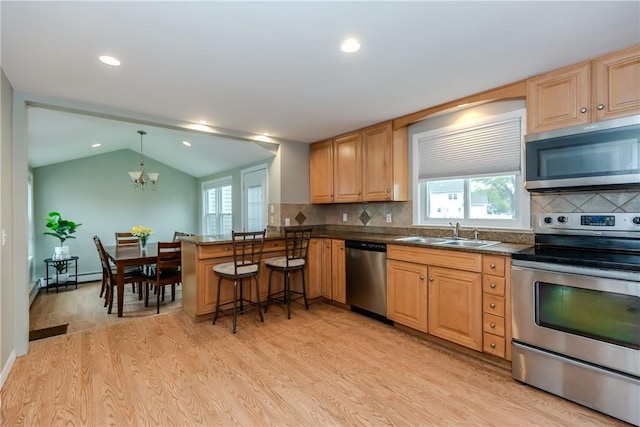 40 Lufkin Ct, Warwick, RI 02888 - kitchen featuring stainless steel appliances, light wood finished floors, a chandelier, lofted ceiling, and dark countertops