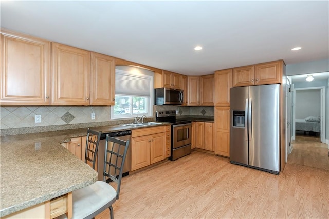40 Lufkin Ct, Warwick, RI 02888 - kitchen featuring stainless steel appliances, light wood finished floors, light brown cabinets, tasteful backsplash, and recessed lighting