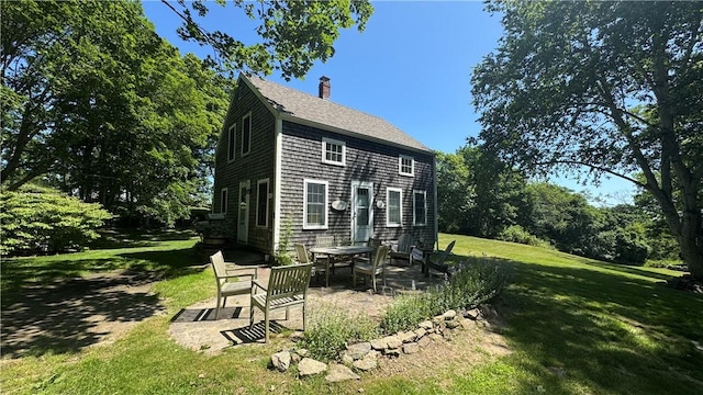 815 Beacon Hill Rd, Block Island, RI 02807 - back of property featuring a patio area, a chimney, a lawn, and a shingled roof