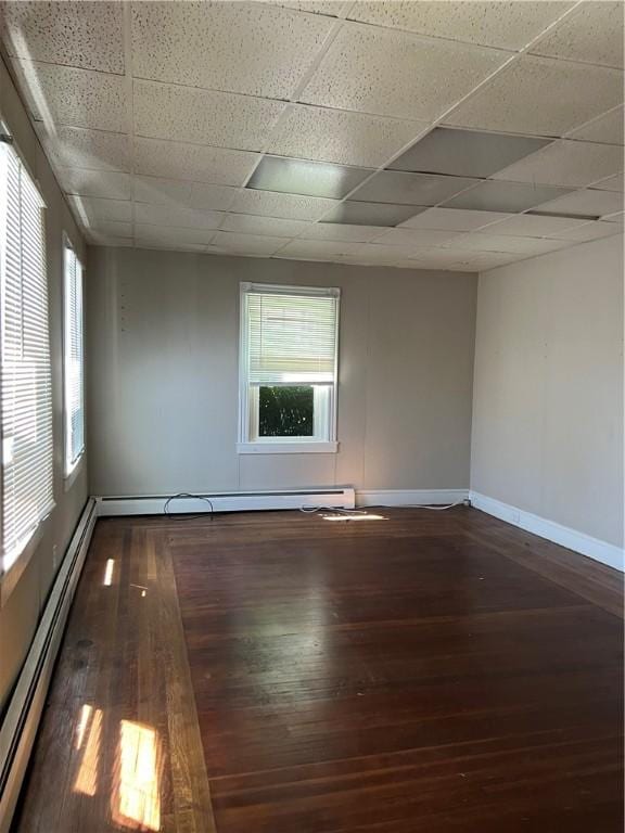 66 Railroad St, South Kingstown, RI 02879 - empty room featuring baseboard heating, wood-type flooring, and a paneled ceiling