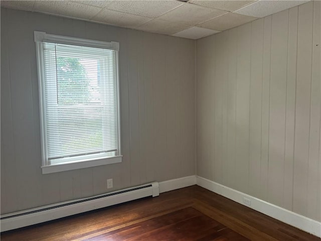 66 Railroad St, South Kingstown, RI 02879 - unfurnished room featuring baseboard heating, dark wood-style flooring, and wooden walls