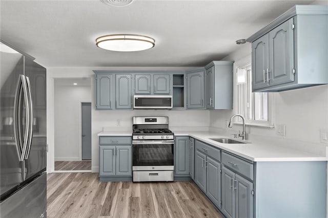 299 George Arden Ave, Warwick, RI 02886 - kitchen featuring appliances with stainless steel finishes, gray cabinets, light wood-style flooring, and light countertops