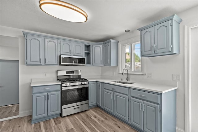 299 George Arden Ave, Warwick, RI 02886 - kitchen with appliances with stainless steel finishes, gray cabinets, open shelves, light wood-type flooring, and decorative light fixtures