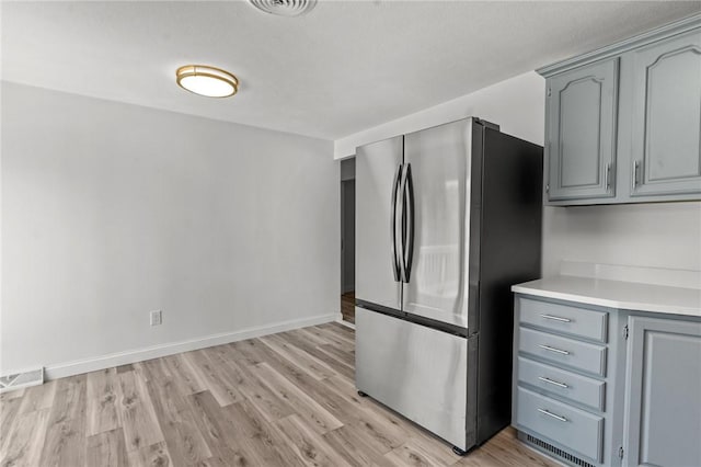 299 George Arden Ave, Warwick, RI 02886 - kitchen with freestanding refrigerator, gray cabinets, light countertops, and light wood-type flooring
