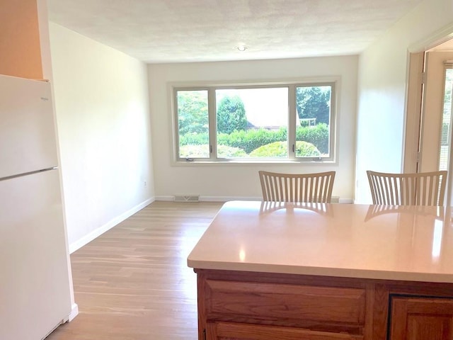 141 Sturbridge Dr, Warwick, RI 02886 - dining room with light wood-style flooring and baseboards