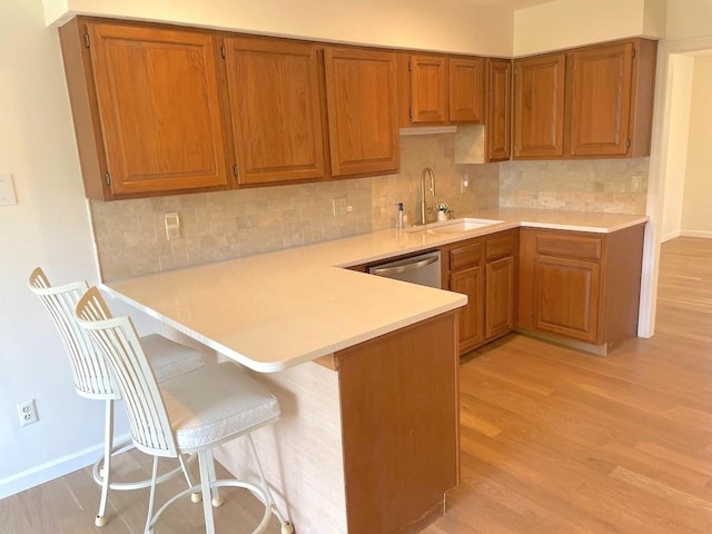 141 Sturbridge Dr, Warwick, RI 02886 - kitchen featuring a peninsula, light wood-type flooring, light countertops, and brown cabinets