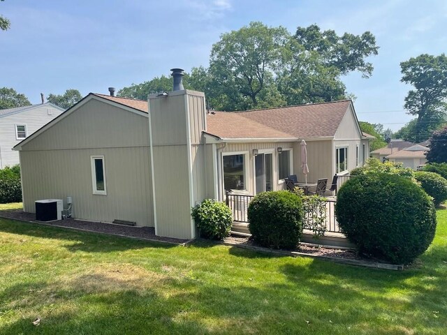 141 Sturbridge Dr, Warwick, RI 02886 - back of house featuring a yard, a chimney, a deck, and roof with shingles