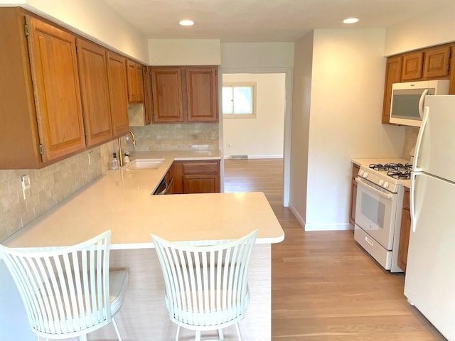 141 Sturbridge Dr, Warwick, RI 02886 - kitchen with white appliances, light countertops, a kitchen bar, a peninsula, and recessed lighting