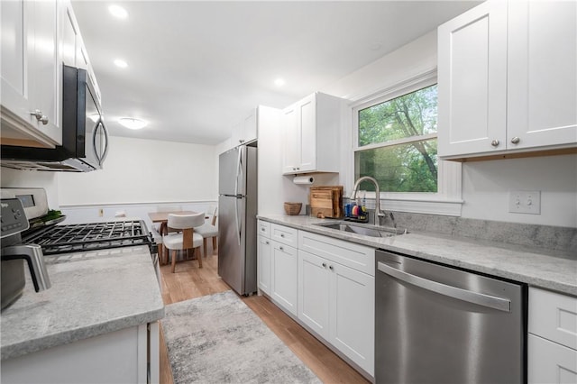607 Knollwood Dr, Woonsocket, RI 02895 - kitchen featuring appliances with stainless steel finishes, white cabinets, light wood-type flooring, light stone countertops, and recessed lighting