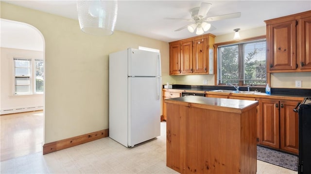 92 Glendale Dr, West Warwick, RI 02893 - kitchen featuring freestanding refrigerator, a kitchen island, a ceiling fan, a baseboard heating unit, and light flooring