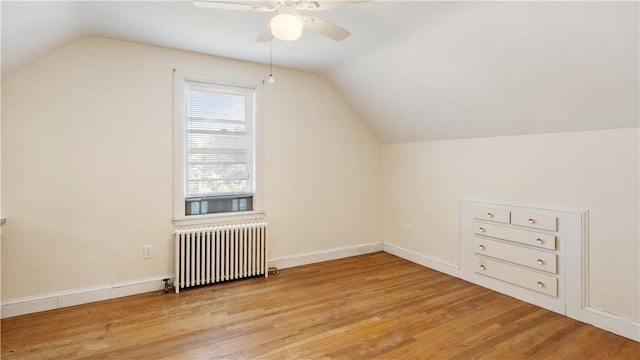 92 Glendale Dr, West Warwick, RI 02893 - additional living space with radiator heating unit, vaulted ceiling, wood finished floors, and a ceiling fan