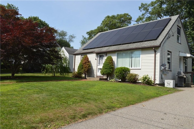 27 Observatory Rd, Warwick, RI 02888 - view of front of home with solar panels, a front yard, and a shingled roof