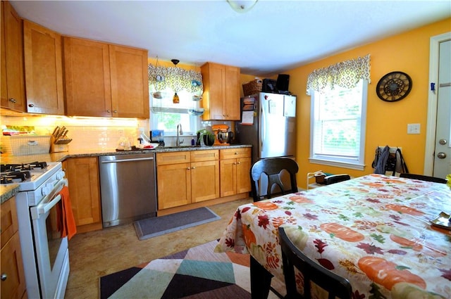 27 Observatory Rd, Warwick, RI 02888 - kitchen featuring appliances with stainless steel finishes, decorative backsplash, light stone countertops, and brown cabinetry
