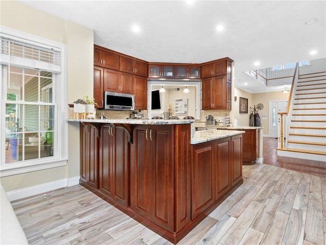 2 Medinah Dr, West Warwick, RI 02893 - kitchen featuring light wood-style flooring, tasteful backsplash, a peninsula, stainless steel microwave, and recessed lighting