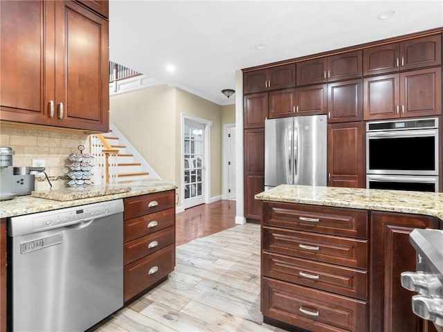 2 Medinah Dr, West Warwick, RI 02893 - kitchen with appliances with stainless steel finishes, crown molding, decorative backsplash, light wood-style flooring, and light stone counters