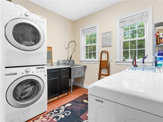 2 Medinah Dr, West Warwick, RI 02893 - laundry area featuring cabinet space, stacked washing machine and dryer, and light tile patterned floors
