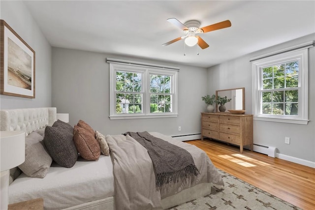 88 Grand View Rd, East Greenwich, RI 02818 - bedroom with baseboard heating, wood finished floors, and a ceiling fan