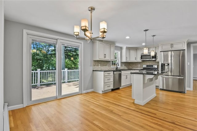 88 Grand View Rd, East Greenwich, RI 02818 - kitchen featuring appliances with stainless steel finishes, a baseboard radiator, dark countertops, backsplash, and light wood-style flooring