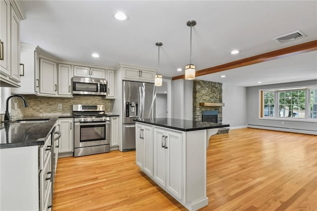 88 Grand View Rd, East Greenwich, RI 02818 - kitchen featuring appliances with stainless steel finishes, light wood finished floors, a baseboard heating unit, tasteful backsplash, and open floor plan