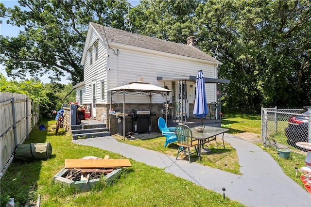 10 Sacramento St, Providence, RI 02909 - back of property featuring a fenced backyard, a chimney, and a gazebo