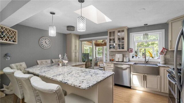 14 Deer Run Dr, Coventry, RI 02816 - kitchen featuring appliances with stainless steel finishes, cream cabinets, a breakfast bar area, and tasteful backsplash