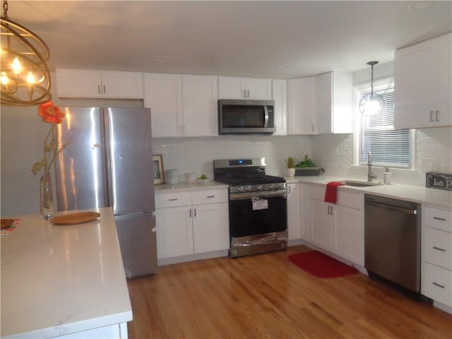 155 Lewiston St, Warwick, RI 02889 - kitchen featuring appliances with stainless steel finishes, light wood-type flooring, light countertops, and white cabinetry