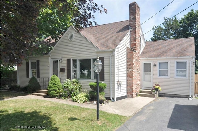 62 Stone Ave, Warwick, RI 02889 - view of front of property with a chimney, entry steps, a front lawn, and a shingled roof
