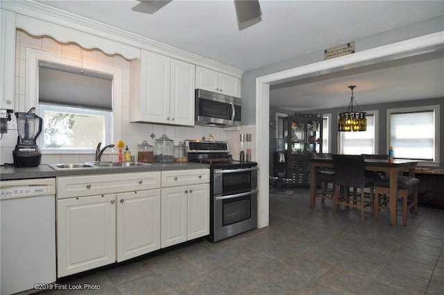62 Stone Ave, Warwick, RI 02889 - kitchen featuring stainless steel appliances, dark countertops, white cabinets, and decorative backsplash