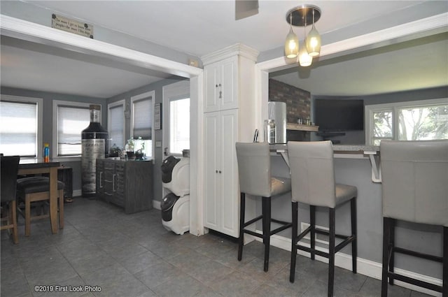 62 Stone Ave, Warwick, RI 02889 - kitchen featuring a kitchen bar, white cabinets, and dark tile patterned floors