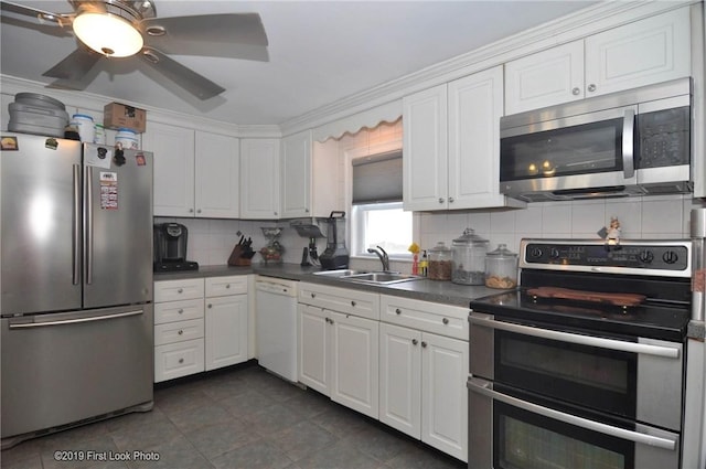 62 Stone Ave, Warwick, RI 02889 - kitchen with stainless steel appliances, dark countertops, decorative backsplash, and white cabinets