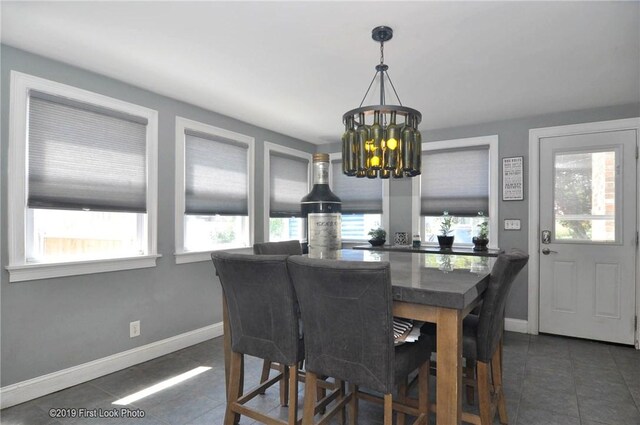 62 Stone Ave, Warwick, RI 02889 - dining area with dark tile patterned flooring and a chandelier