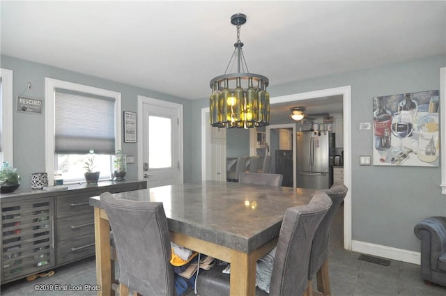 62 Stone Ave, Warwick, RI 02889 - dining room with dark tile patterned floors and a chandelier