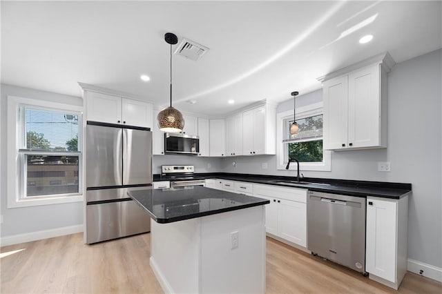 312 Veazie St, Providence, RI 02904 - kitchen with appliances with stainless steel finishes, light wood-type flooring, white cabinets, recessed lighting, and hanging light fixtures