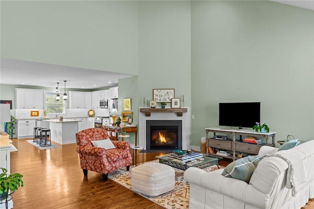 83 Silas Hill Way, Exeter, RI 02822 - living room featuring wood finished floors, high vaulted ceiling, a fireplace with flush hearth, and recessed lighting