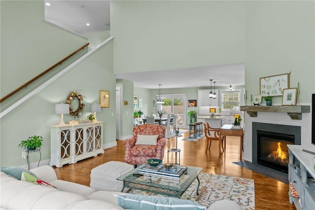 83 Silas Hill Way, Exeter, RI 02822 - living area featuring wood finished floors, a high ceiling, recessed lighting, stairway, and a fireplace with flush hearth